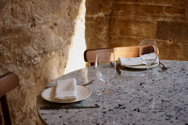Mesa puesta junto a la pared de piedra del restaurante